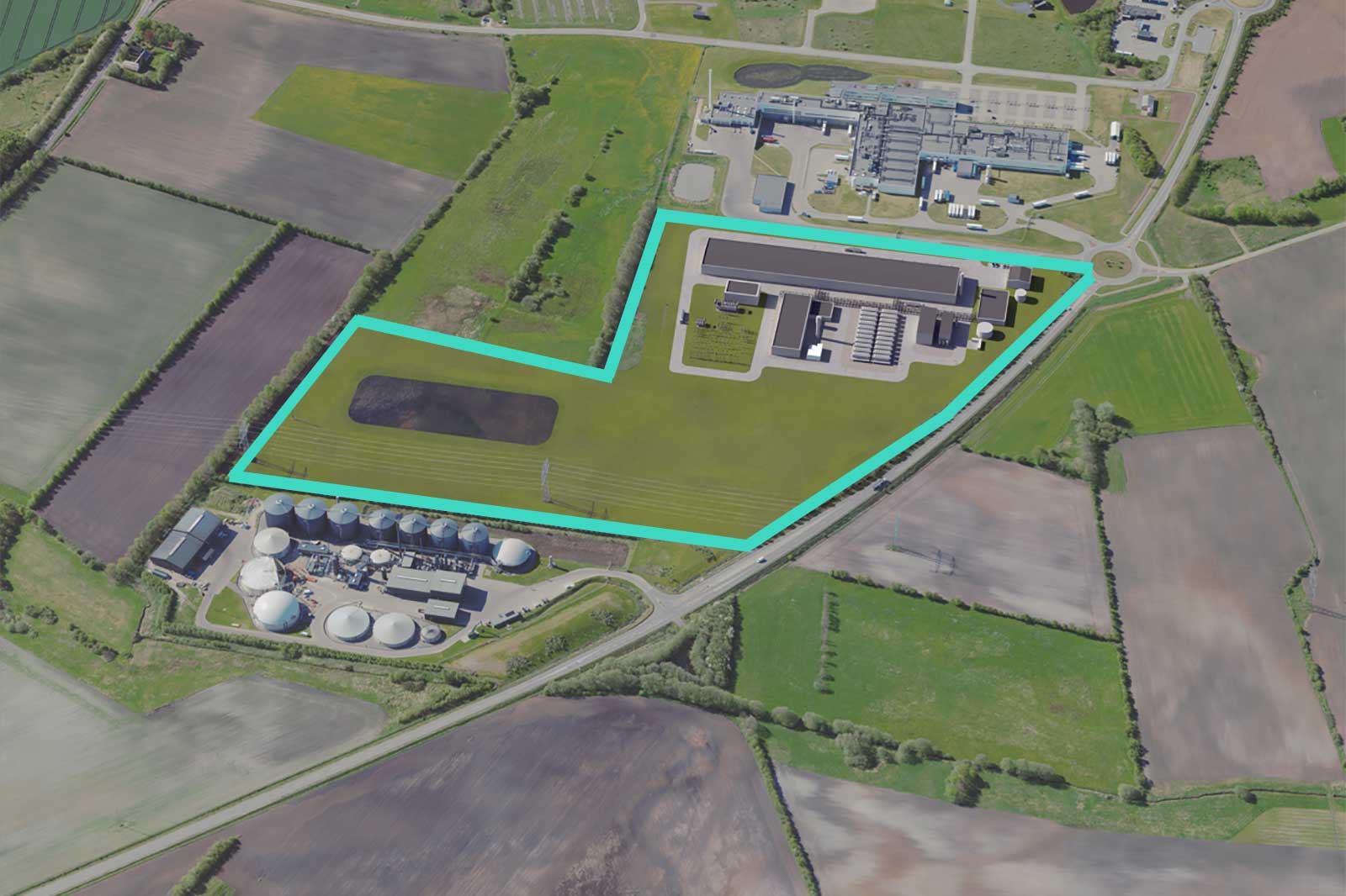 An aerial view shows an industrial complex outlined in cyan, with gray buildings, white dome tanks, a dark pond and green fields.